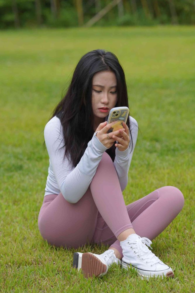 图片[1]-坐在草地玩手机的瑜伽姑娘【733P】04012-街头图